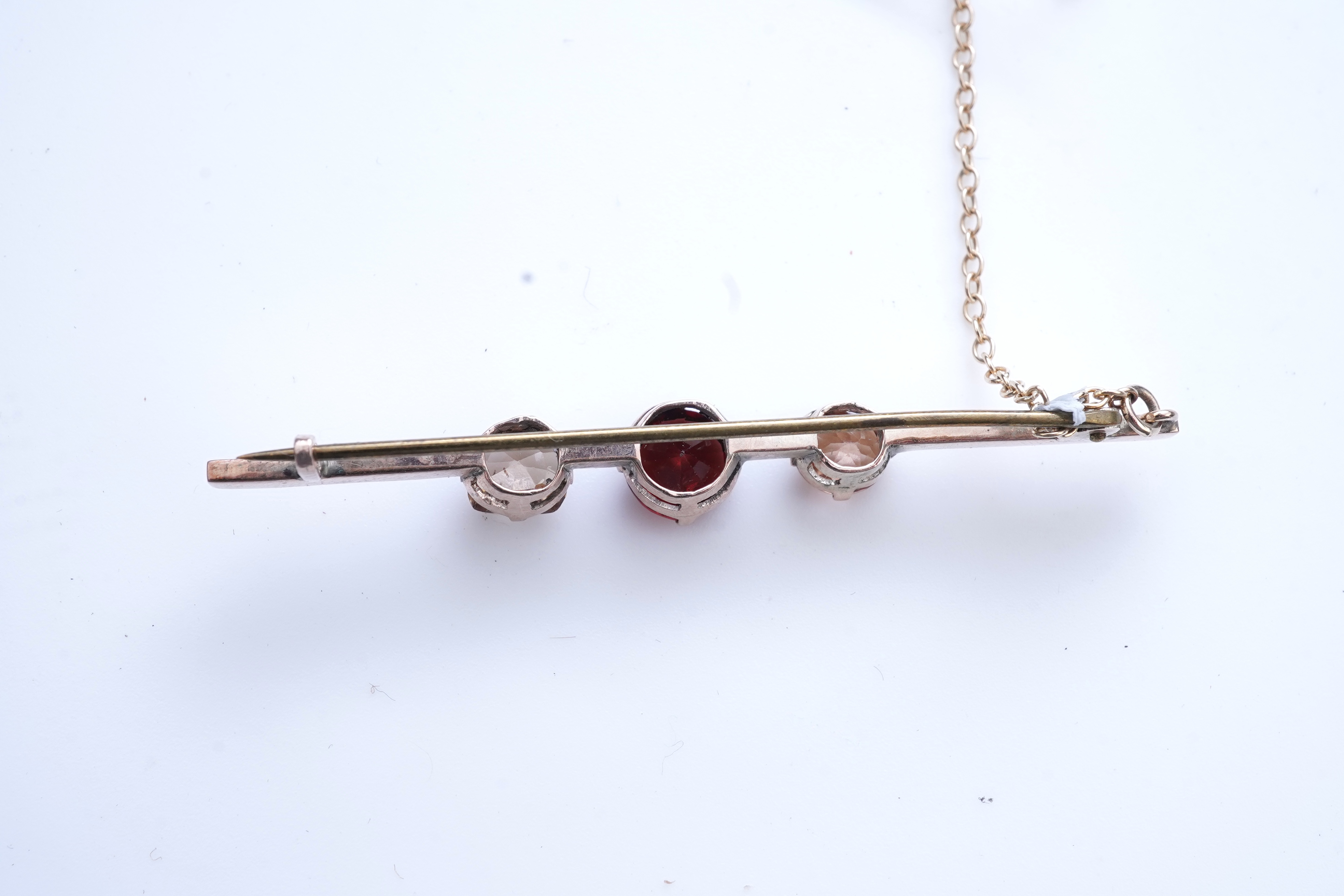 A Victorian yellow metal, amethyst and garnet cluster set brooch, 22mm, an early 20th century yellow metal and seed pearl set heart shaped locket, a yellow metal, garnet and zircon set three stone bar brooch and a tortoi